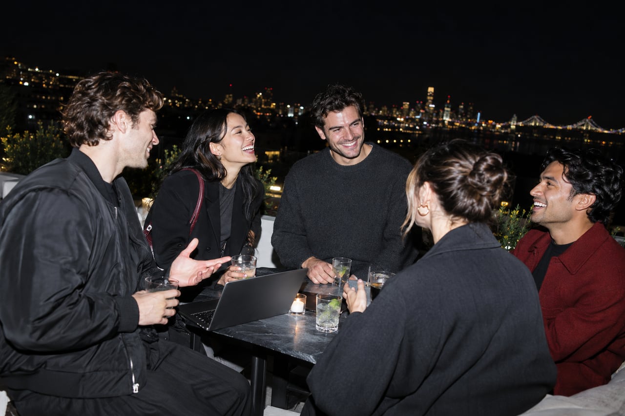 Founders share a lively conversation at a San Francisco rooftop meetup after dark.